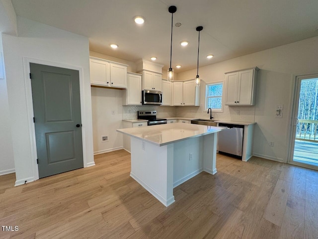 kitchen with white cabinets, a center island, sink, and stainless steel appliances