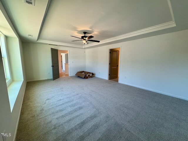 empty room with carpet floors, a raised ceiling, ceiling fan, and crown molding