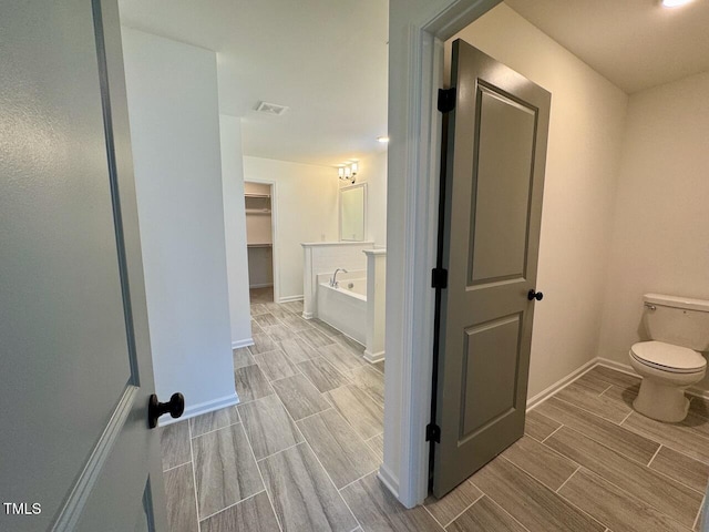 bathroom featuring toilet and a tub