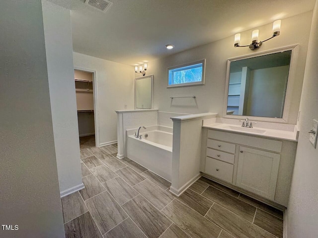 bathroom featuring a tub to relax in and vanity