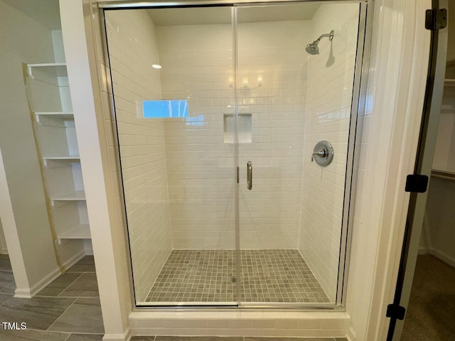 bathroom with tile patterned flooring and a shower with door