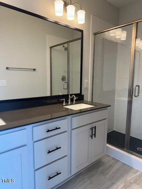 bathroom with vanity, a shower with door, and tile patterned flooring