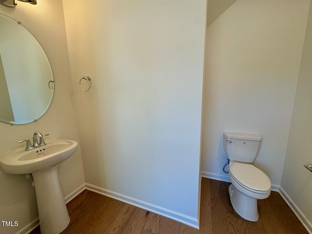 bathroom with hardwood / wood-style flooring and toilet