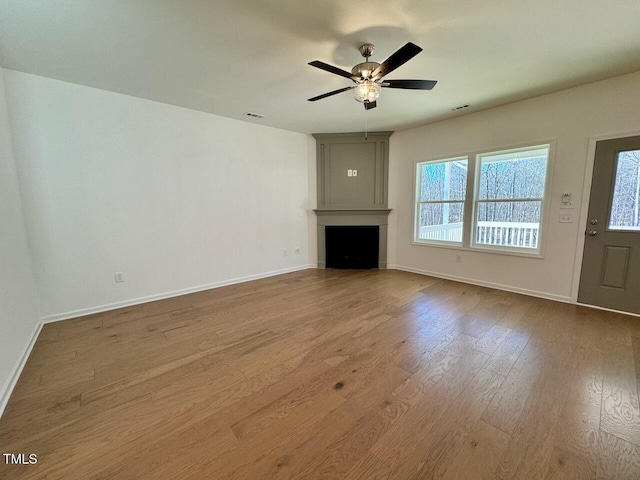 unfurnished living room with wood-type flooring and ceiling fan