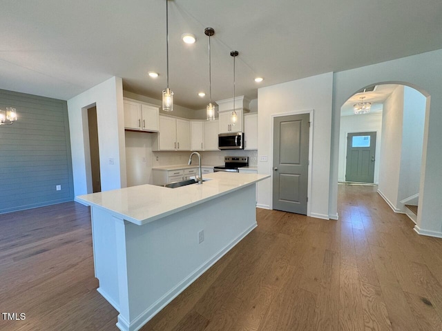 kitchen featuring stainless steel appliances, sink, a kitchen island with sink, and white cabinets