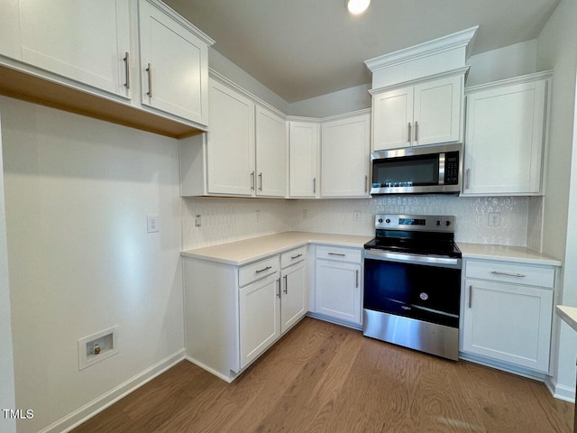 kitchen featuring decorative backsplash, light hardwood / wood-style flooring, white cabinets, and appliances with stainless steel finishes