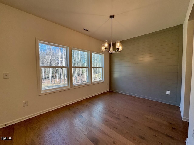 unfurnished dining area with hardwood / wood-style flooring and a notable chandelier