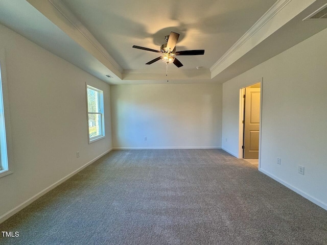 carpeted empty room featuring a tray ceiling, ornamental molding, and ceiling fan