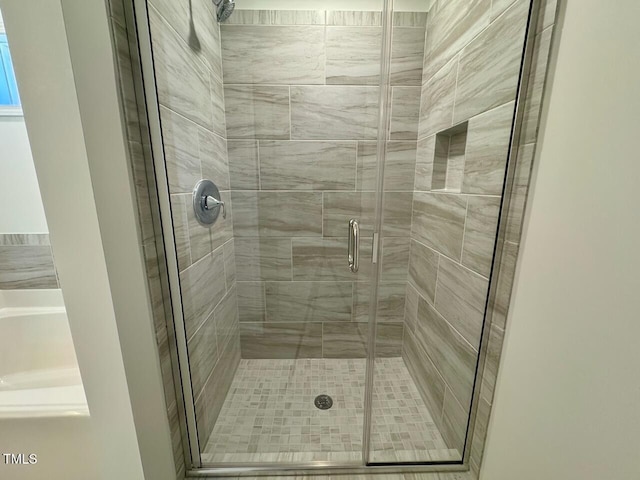 bathroom featuring a shower with shower door