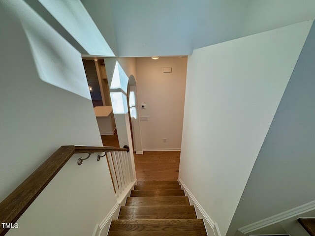 staircase featuring baseboards and wood finished floors