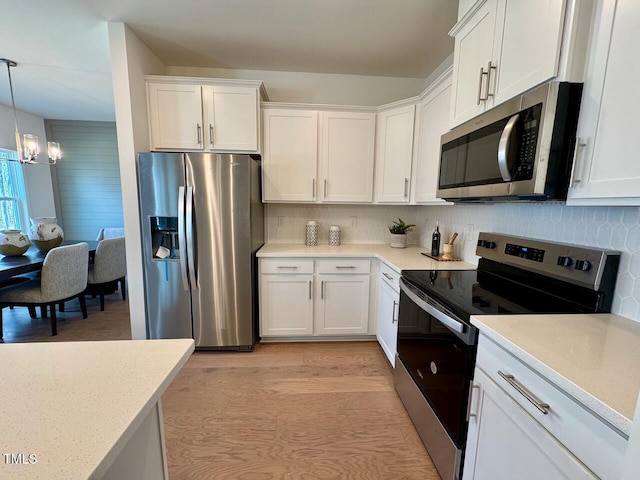 kitchen featuring stainless steel appliances, light countertops, and white cabinetry