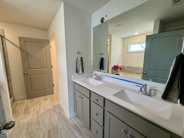 full bathroom featuring double vanity, visible vents, and a sink