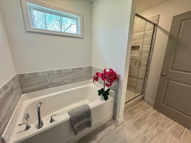 full bathroom featuring a garden tub and a shower stall