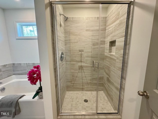 full bath with a stall shower and a bath