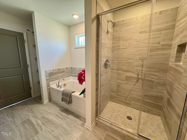 full bathroom featuring a shower stall and a bath