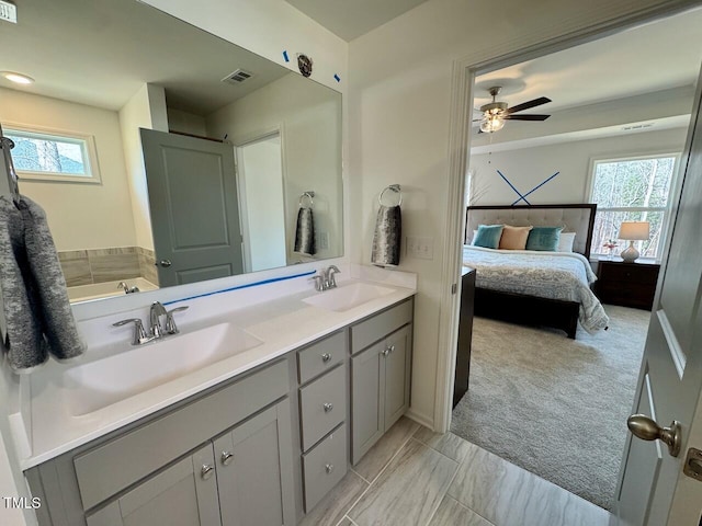 ensuite bathroom featuring double vanity, ensuite bath, visible vents, and a sink