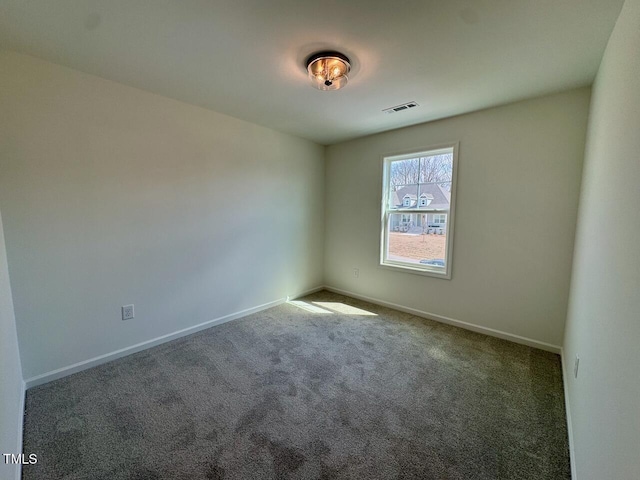 empty room featuring carpet floors, visible vents, and baseboards