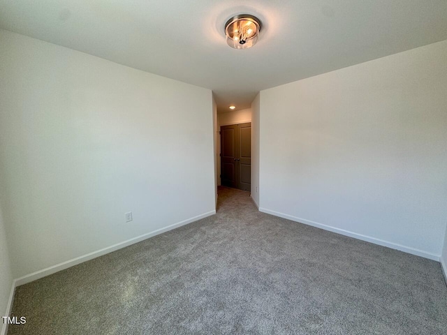 empty room featuring carpet floors and baseboards