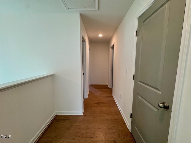 hallway featuring dark wood-style floors and baseboards