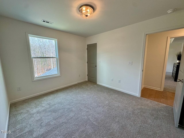 unfurnished bedroom with carpet, visible vents, and baseboards