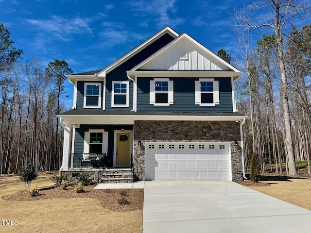 view of front facade featuring driveway, a garage, stone siding, covered porch, and board and batten siding