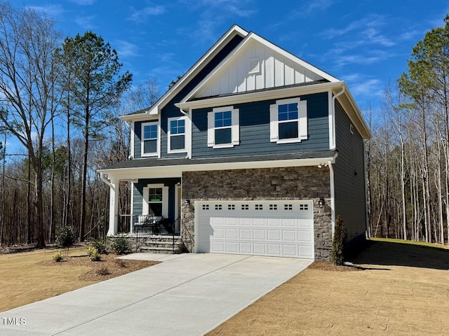 view of front of house featuring covered porch, stone siding, board and batten siding, and concrete driveway