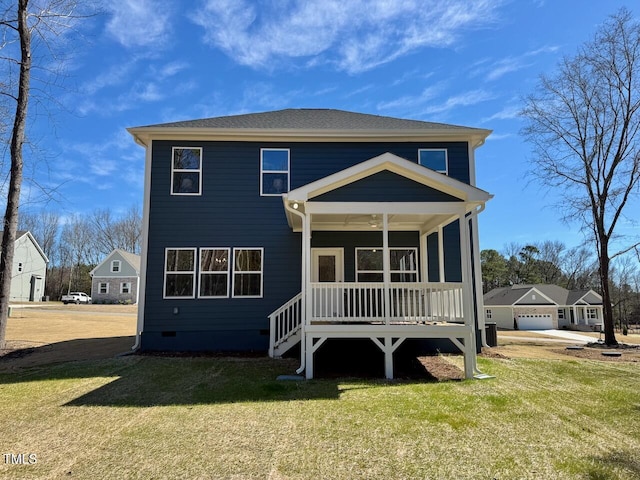 rear view of house featuring crawl space, covered porch, and a yard