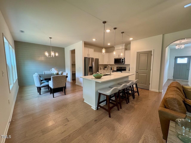 196 Grand Griffon Way, Lillington, NC 27546 - kitchen with appliances with stainless steel finishes, a chandelier, a sink, arched walkways, and baseboards