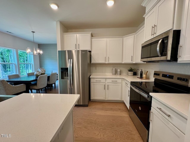 196 Grand Griffon Way, Lillington, NC 27546 - kitchen with stainless steel appliances, a chandelier, white cabinetry, light countertops, and decorative light fixtures