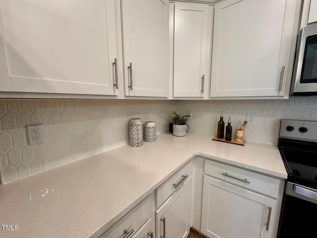 196 Grand Griffon Way, Lillington, NC 27546 - kitchen featuring appliances with stainless steel finishes, light countertops, white cabinets, and tasteful backsplash