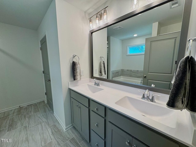 196 Grand Griffon Way, Lillington, NC 27546 - bathroom featuring baseboards, double vanity, and a bath