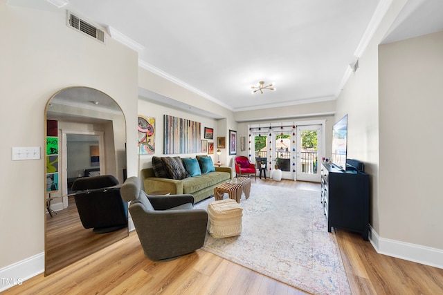 living room featuring french doors, light hardwood / wood-style flooring, and ornamental molding