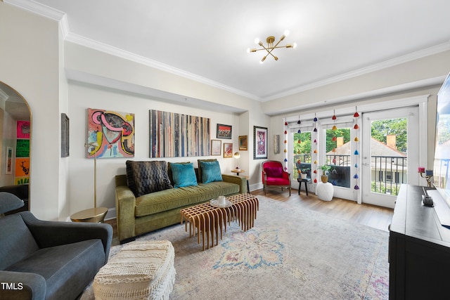 living room with light hardwood / wood-style floors, a chandelier, and ornamental molding