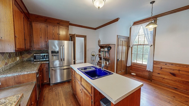 kitchen with stainless steel appliances, sink, hanging light fixtures, a kitchen island with sink, and dark hardwood / wood-style flooring