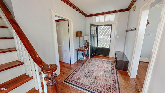 entryway with stairs, ornamental molding, light wood-type flooring, and baseboards