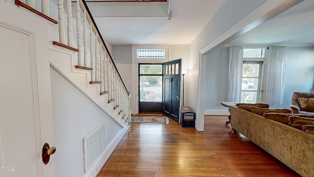 entrance foyer featuring stairway, baseboards, visible vents, and dark wood-type flooring