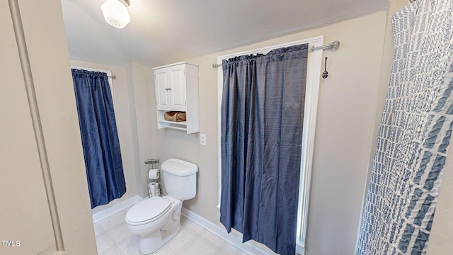 full bath with a shower with curtain, tile patterned floors, toilet, and baseboards