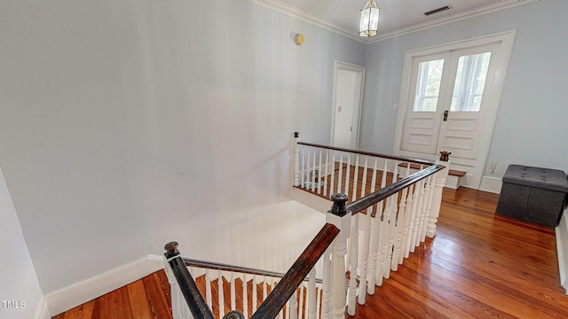 staircase featuring french doors, crown molding, visible vents, wood finished floors, and baseboards