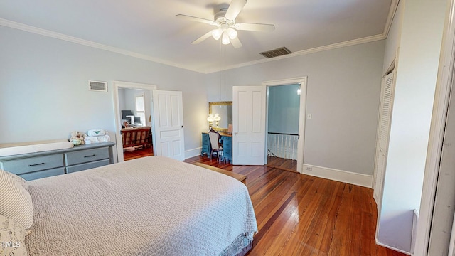 bedroom featuring dark wood-style floors, baseboards, visible vents, and ornamental molding