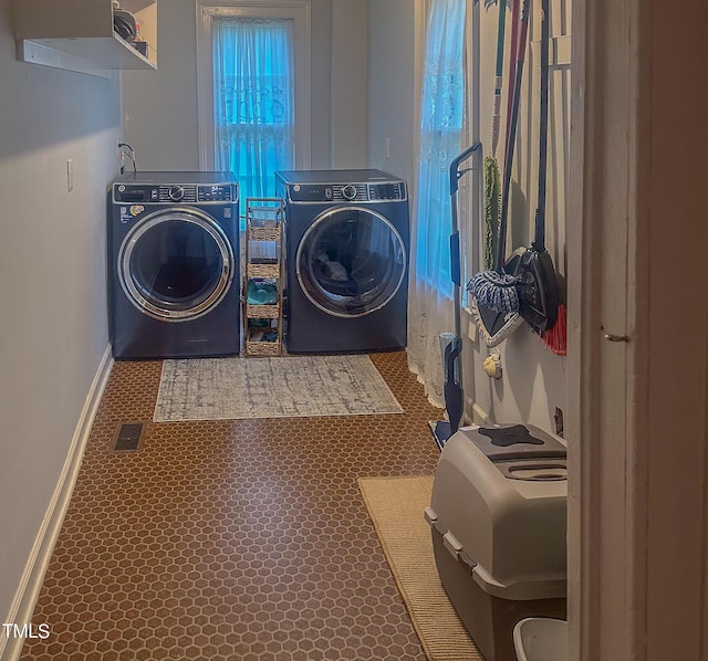 laundry room featuring laundry area, visible vents, washing machine and clothes dryer, and baseboards