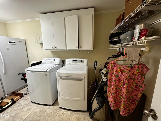 laundry area with crown molding, cabinets, and washer and dryer