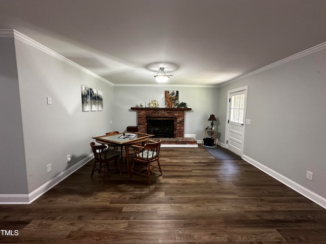 dining space with dark wood-type flooring, ornamental molding, and a brick fireplace