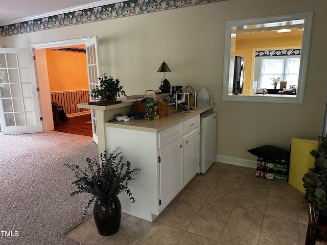 interior space with stainless steel dishwasher, black fridge with ice dispenser, and white cabinets