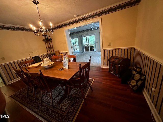 dining room with dark hardwood / wood-style flooring, crown molding, and an inviting chandelier