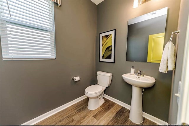 bathroom featuring wood-type flooring and toilet