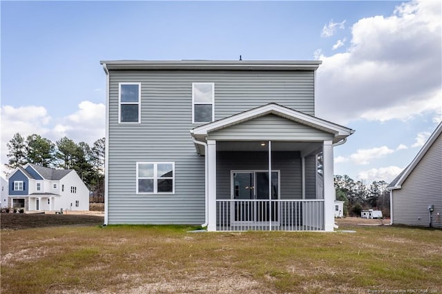 back of property with a porch and a lawn