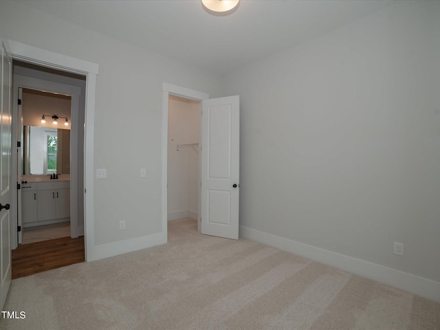 16 Autumn Breeze Ct, Angier, NC 27501 - unfurnished bedroom with carpet flooring, a spacious closet, baseboards, and a sink