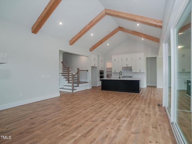 16 Autumn Breeze Ct, Angier, NC 27501 - living area with beam ceiling, high vaulted ceiling, stairway, light wood-style floors, and baseboards