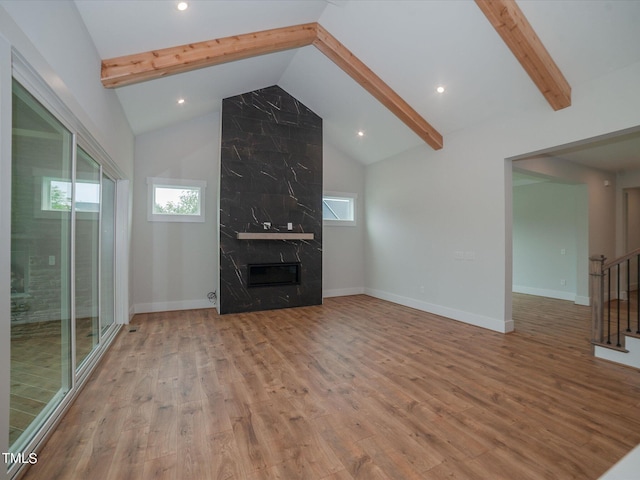 16 Autumn Breeze Ct, Angier, NC 27501 - unfurnished living room with beam ceiling, wood finished floors, a fireplace, stairway, and high vaulted ceiling