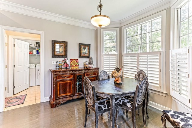 dining space featuring washing machine and dryer, plenty of natural light, ornamental molding, and light hardwood / wood-style flooring